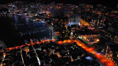 Karadağ dağlarının yamaçlarına ve Adriyatik Denizi yakınlarındaki yıldızlı karanlık gökyüzüne karşı renkli elektrik ışıkları ve plajları olan bir turizm şehri. UHD Video gerçek zamanlı 4K