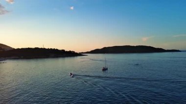 Budva ve Becici tatil beldeleri, sakin Adriyatik Denizi yakınlarında lüks oteller ve rahat plajlarla Karadağ Dağları ve mavi gökyüzüne karşı. UHD Video gerçek zamanlı 4K