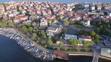 Bulgaristan 'ın kayalık yarımadasında bulunan ve büyük mavi, tuzlu Karadeniz tarafından turlanan küçük ve yoğun nüfuslu Pomorie kasabasına kuş bakışı bir bakış. UHD 4K video gerçek zamanlı