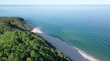 Yaz tatilleri için otelleri ve hanları olan küçük bir tatil köyü yeşil bitki örtüsü ile kayalık ve keskin uçurumlar üzerinde, açık mavi gökyüzüne karşı vahşi Karadeniz üzerinde. UHD 4K video gerçek zamanlı