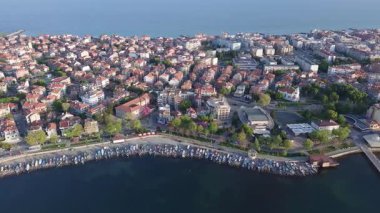 Bulgaristan 'ın kayalık yarımadasında bulunan ve büyük mavi, tuzlu Karadeniz tarafından turlanan küçük ve yoğun nüfuslu Pomorie kasabasına kuş bakışı bir bakış. UHD 4K video gerçek zamanlı