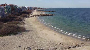 Bulgaristan 'ın kayalık yarımadasında bulunan ve büyük mavi, tuzlu Karadeniz tarafından turlanan küçük ve yoğun nüfuslu Pomorie kasabasına kuş bakışı bir bakış. UHD 4K video gerçek zamanlı