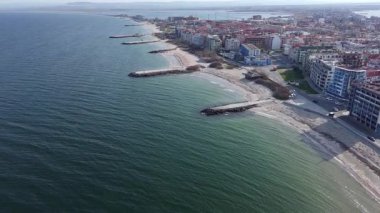 Bulgaristan 'ın kayalık yarımadasında bulunan ve büyük mavi, tuzlu Karadeniz tarafından turlanan küçük ve yoğun nüfuslu Pomorie kasabasına kuş bakışı bir bakış. UHD 4K video gerçek zamanlı