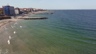 Bulgaristan 'ın kayalık yarımadasında bulunan ve büyük mavi, tuzlu Karadeniz tarafından turlanan küçük ve yoğun nüfuslu Pomorie kasabasına kuş bakışı bir bakış. UHD 4K video gerçek zamanlı