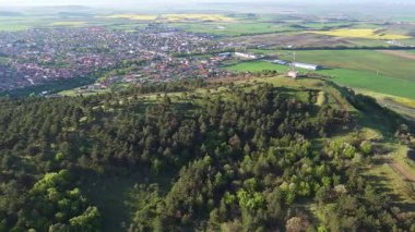 Birds eye view of spring blooming green meadows and wooded hilly slopes of the Balkan Mountains, under the light of a bright cloudy warm day in the country of Bulgaria. UHD 4K video realtime