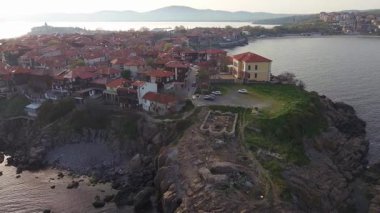 Birds eye view of the modern historic small town of Sozopol with a variety of cozy seaside houses and small sea spring boats, near the calm deep rippled Black Sea. UHD 4K video realtime