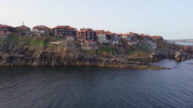 Birds eye view of the modern historic small town of Sozopol with a variety of cozy seaside houses and small sea spring boats, near the calm deep rippled Black Sea. UHD 4K video realtime