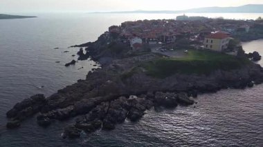Birds eye view of the modern historic small town of Sozopol with a variety of cozy seaside houses and small sea spring boats, near the calm deep rippled Black Sea. UHD 4K video realtime