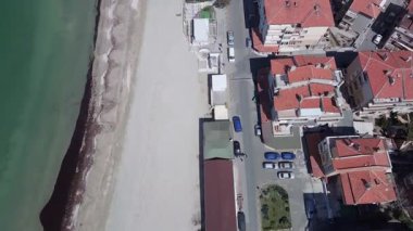 Bulgaristan 'ın kayalık yarımadasında bulunan ve büyük mavi, tuzlu Karadeniz tarafından turlanan küçük ve yoğun nüfuslu Pomorie kasabasına kuş bakışı bir bakış. UHD 4K video gerçek zamanlı