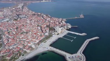 Küçük, yeni inşa edilmiş bir tatil köyünün kuş bakışı manzarası - Pomorie yarımadası, büyük, tuzlu, sakin Karadeniz 'de birçok farklı modern tekne ve tekne. UHD 4K video gerçek zamanlı