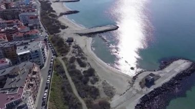Bulgaristan 'ın kayalık yarımadasında bulunan ve büyük mavi, tuzlu Karadeniz tarafından turlanan küçük ve yoğun nüfuslu Pomorie kasabasına kuş bakışı bir bakış. UHD 4K video gerçek zamanlı