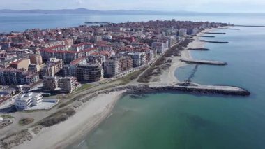 Bulgaristan 'ın kayalık yarımadasında bulunan ve büyük mavi, tuzlu Karadeniz tarafından turlanan küçük ve yoğun nüfuslu Pomorie kasabasına kuş bakışı bir bakış. UHD 4K video gerçek zamanlı