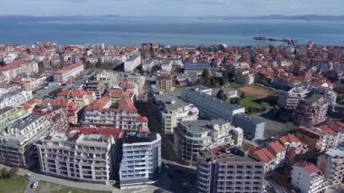 Bulgaristan 'ın kayalık yarımadasında bulunan ve büyük mavi, tuzlu Karadeniz tarafından turlanan küçük ve yoğun nüfuslu Pomorie kasabasına kuş bakışı bir bakış. UHD 4K video gerçek zamanlı