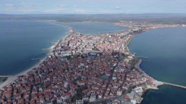Bulgaristan 'ın kayalık yarımadasında bulunan ve büyük mavi, tuzlu Karadeniz tarafından turlanan küçük ve yoğun nüfuslu Pomorie kasabasına kuş bakışı bir bakış. UHD 4K video gerçek zamanlı