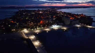 Bulgaristan 'ın Pomorie kentinde, bulutlu, çok renkli gökyüzü ve parlak akşam batımıyla birlikte deniz ufkunun arka planında, sakin Karadeniz' de büyüleyici bir yansıma görülüyor. UHD 4K video gerçek zamanlı