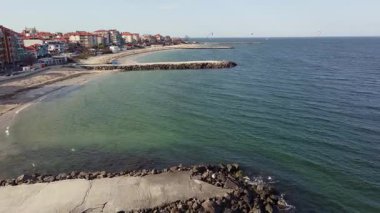 Bulgaristan 'ın kayalık yarımadasında bulunan ve büyük mavi, tuzlu Karadeniz tarafından turlanan küçük ve yoğun nüfuslu Pomorie kasabasına kuş bakışı bir bakış. UHD 4K video gerçek zamanlı