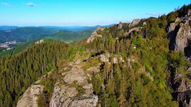 View from high rock to old village town Smolyan with green meadows for cattle walking and houses, between mountain range of Rhodope Mountains sheltered by spruce forests. UHD 4K video realtime