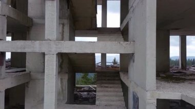 Rodop Dağları 'nın dağ ormanlarındaki vahşi vadisinde otoyol boyunca uzanan çok katlı ve bitmemiş büyük bir bina. UHD 4K video gerçek zamanlı