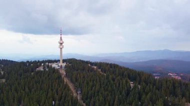 Snezhana 'nın dağlık tepesindeki yüksek turist gözlem kulesi Rodop dağları ve tepelerindeki yeşil ladin yoğun ormanlarıyla kaplıydı. UHD 4K video gerçek zamanlı