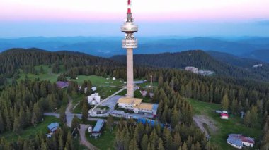 Snezhana 'nın dağlık tepesindeki yüksek turist gözlem kulesi Rodop dağları ve tepelerindeki yeşil ladin yoğun ormanlarıyla kaplıydı. UHD 4K video gerçek zamanlı