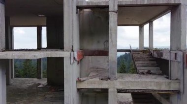 Rodop Dağları 'nın dağ ormanlarındaki vahşi vadisinde otoyol boyunca uzanan çok katlı ve bitmemiş büyük bir bina. UHD 4K video gerçek zamanlı