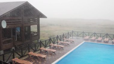 İnanılmaz derecede şiddetli yağmur ve hızlı, sert rüzgar uzun zamandır beklenen bir tatil için sakin bir üssün ılık ve güneşli yaz havasını bozuyor. 4K UHD yavaş çekim videosu