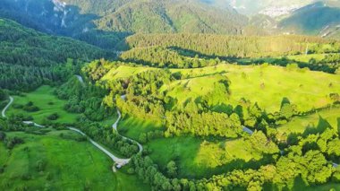 View from high rock to old village town Smolyan with green meadows for cattle walking and houses, between mountain range of Rhodope Mountains sheltered by spruce forests. UHD 4K video realtime