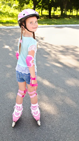 Cute smiling little girl in pink roller skates — Stock Photo, Image