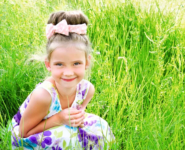 Adorável sorrindo menina no prado no dia de verão — Fotografia de Stock