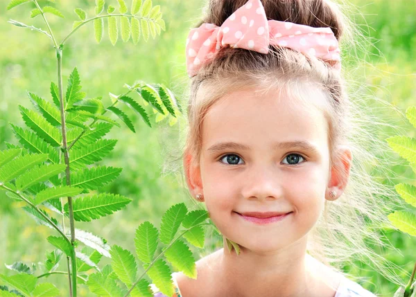 Yaz günü çayır üzerinde gülümseyen sevimli küçük kız — Stok fotoğraf