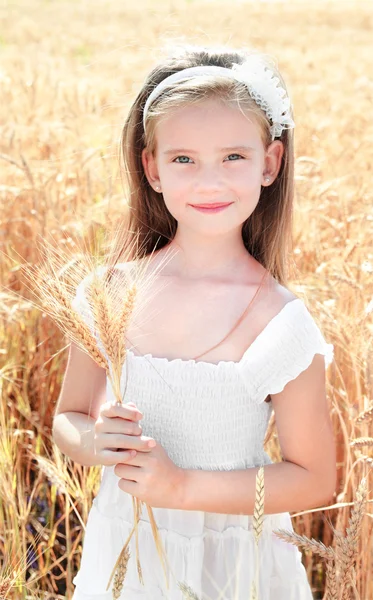 Sonriente linda niña en el campo de trigo —  Fotos de Stock