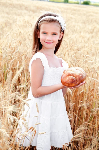 Smiling little girl on field of wheat — Stock Photo, Image