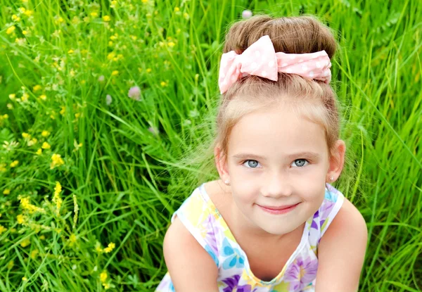 Adorable niña sonriente en el prado en el día de verano —  Fotos de Stock