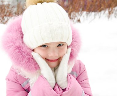 Kış günü sevimli gülümseyen küçük kız portresi