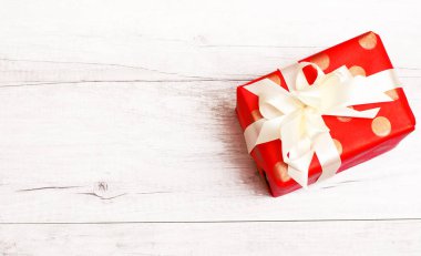 Noel ve Yeni Yıl geçmişi. Tahta zeminde izole edilmiş kurdele ve yayla Noel hediyesi. Üst görünüm ve kopyalama alanı