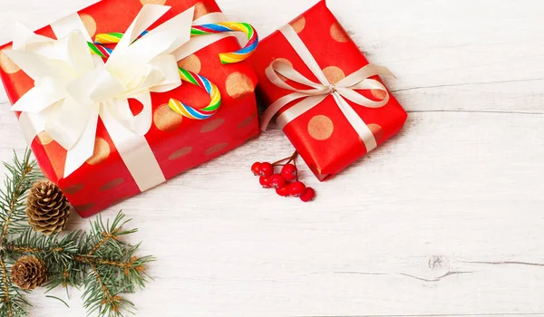 圣诞和新年作文 采购产品圣诞礼物 冷杉树枝 棒棒糖 红色的浆果在木制的白色背景 顶部视图 — 图库照片
