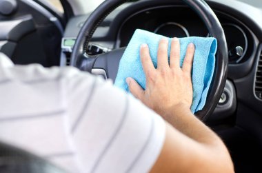 Arabanın içini temizliyorum. Erkek el dezenfekte vihicle tekerleği. Virüs hastalığından korunmak için içeriyi temizliyorum.