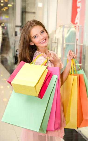 Hermosa Niña Sonriente Feliz Niño Está Sosteniendo Bolsas Compras Centro —  Fotos de Stock