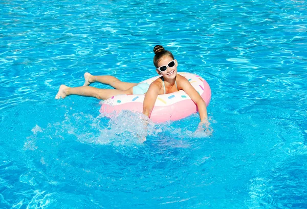 ゴム製のリングでプールでかわいい笑顔の女の子 夏休みを楽しんでいる子供 — ストック写真