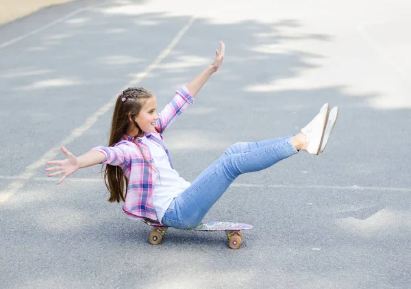 在滑板上开心地微笑着可爱的小女孩在滑冰 夏天的时候 十几岁的孩子在户外的一块板上骑马 — 图库照片