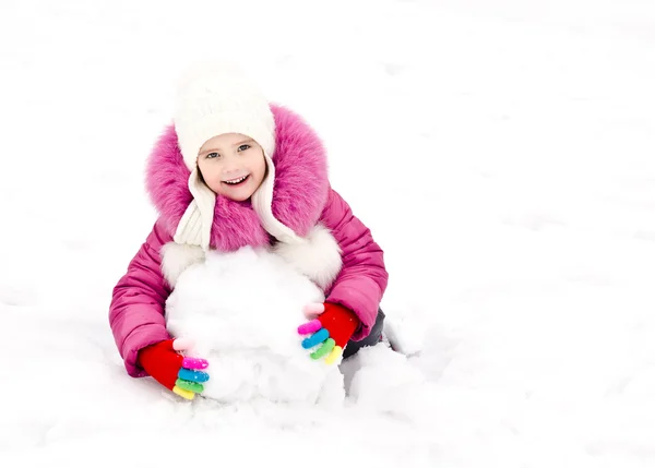 Bonito sorrindo menina faz boneco de neve no dia de inverno — Fotografia de Stock