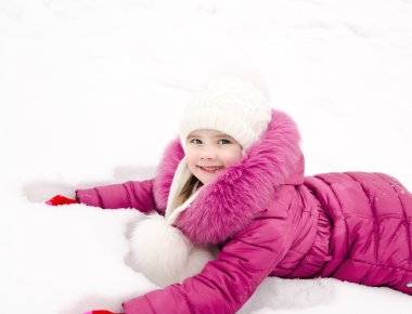 sevimli gülümseyen küçük kız kış günü kar üzerinde yalan