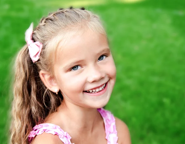 Портрет очаровательной улыбающейся маленькой девочки в парке — стоковое фото