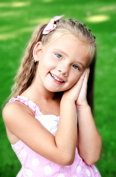 Portrét rozkošný usměvavá holčička v parku — Stock fotografie