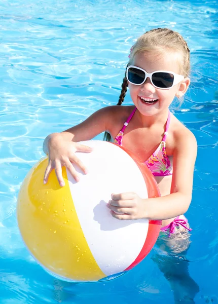 Niña sonriente con bola en la piscina —  Fotos de Stock