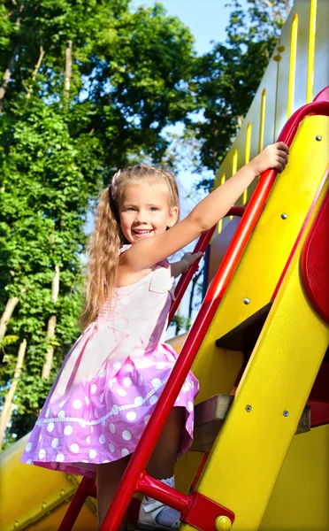 Little girl is climbing up on ladder in playground equipment — Stock Photo, Image
