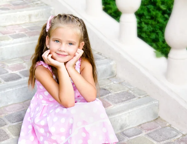 Portrait of adorable little girl sitting on steps — Stock Photo, Image