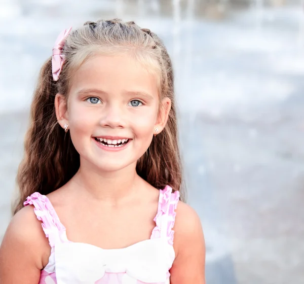 Portrét rozkošný usměvavá holčička v parku — Stock fotografie