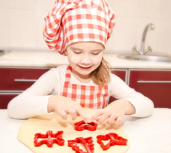 Маленькая девочка режет тесто с формой для печенья — стоковое фото