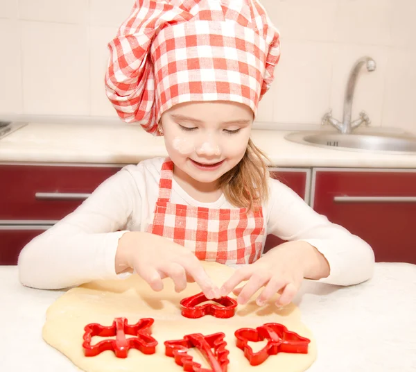 Liten flicka skär degen med form för cookies — Stockfoto